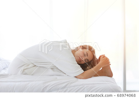 Young woman in sleepwear hand enjoying in meditate with yoga pose on bed before go to bed or wake up 68974068
