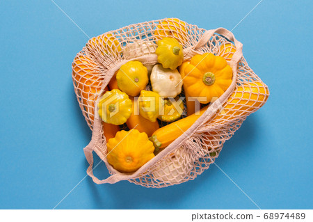 Yellow zucchini and pattison on blue background 68974489