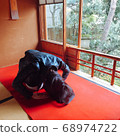 Pretty woman with dark hair bowing in a Japanese-style room 68974722