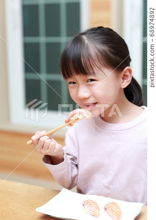 女孩吃大西洋鮭魚飯壽司 68974892