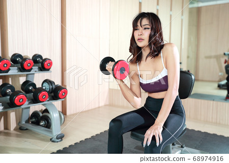 fitness girl lifting dumbbell and workout in gym fitness girl lifting dumbbell and workout in gym 68974916