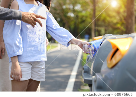 asian family in the park, parents teaching children to throw empty plastic bottle into the garbage 68976665