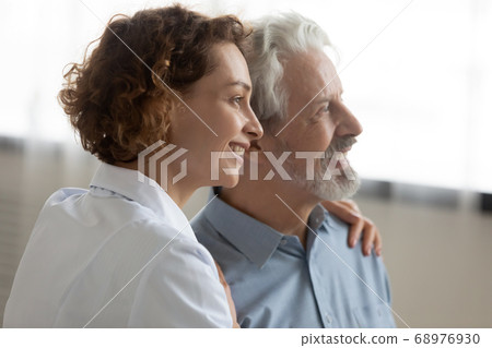 Close up smiling caregiver and mature patient looking to aside 68976930