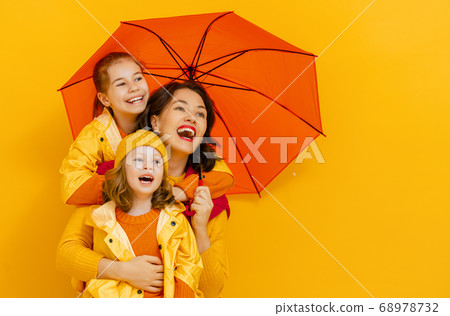 Family with umbrella on colored background. 68978732