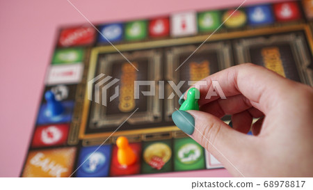 Hand on the background of colorful blurred Board games 68978817