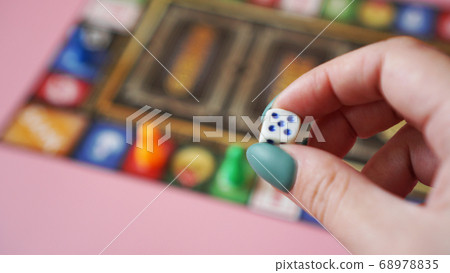 Hand throws the dice on the background of colorful blurred Board games Hand throws the dice on the background of colorful blurred Board games 68978835