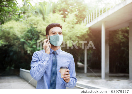 Young Asian Businessman Wearing a Surgical Mask Young Asian Businessman Wearing a Surgical Mask 68979157