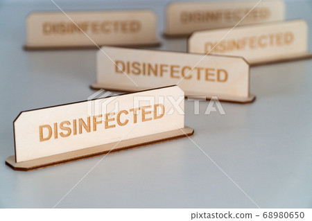 COVID-19. Wooden name plate with inscription DISINFECTED COVID-19. Wooden name plate with inscription DISINFECTED 68980650