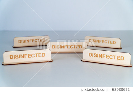 COVID-19. Wooden name plate with inscription DISINFECTED 68980651