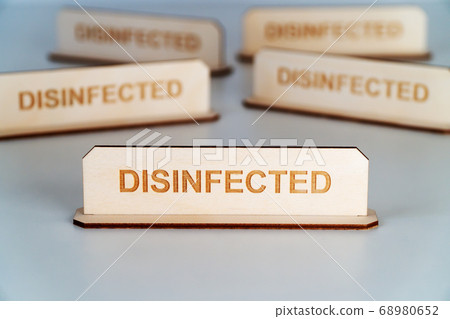 COVID-19. Wooden name plate with inscription DISINFECTED 68980652