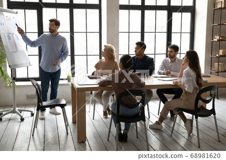 Skilled young sales trainer giving educational lecture to business people. 68981620
