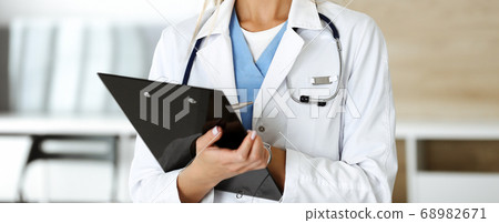 Unknown woman-doctor controls medication history record and medical exam results, close-up. Medicine concept Unknown woman-doctor controls medication history record and medical exam results, close-up. Medicine concept 68982671