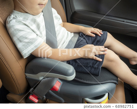 Child sitting in child seat with seat belt 68982751
