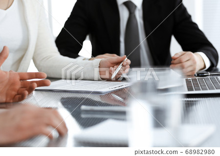 Business people discussing contract working together at meeting in modern office. Unknown businessman and woman with colleagues or lawyers at negotiation Business people discussing contract working together at meeting in modern office. Unknown businessman and woman with colleagues or lawyers at negotiation 68982980