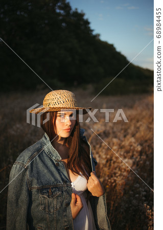 Beautiful woman walking alone in summer nature Beautiful woman walking alone in summer nature 68984455