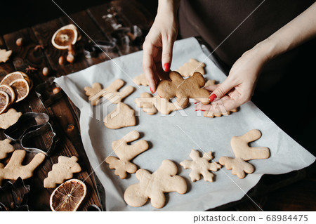 Woman hands with homemade gingerbread cookies Woman hands with homemade gingerbread cookies 68984475