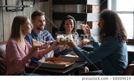 Happy diverse friends eating pizza and having fun in cafe Happy diverse friends eating pizza and having fun in cafe 68984614