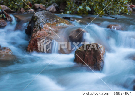 Nature scene of rough, fast flowing river hitting Nature scene of rough, fast flowing river hitting 68984964