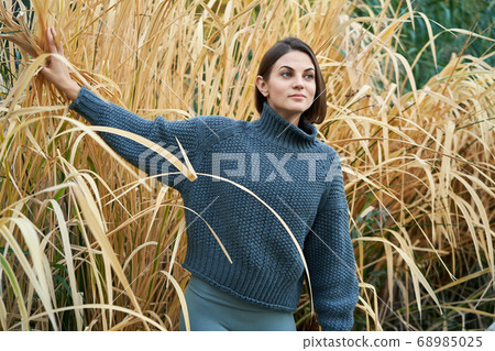 Young pretty woman in blue pullover in the yellow grass Young pretty woman in blue pullover in the yellow grass 68985025