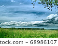 Blue sky with clouds, and green grass on the field 68986107