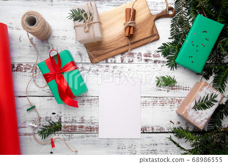 a sheet of paper lies on a white table next to gifts 68986555