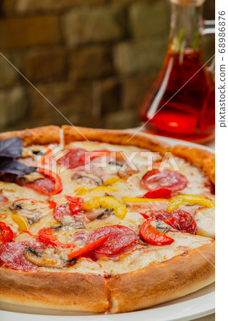 Fresh hot pizza on white plate in restaurant. 68986876