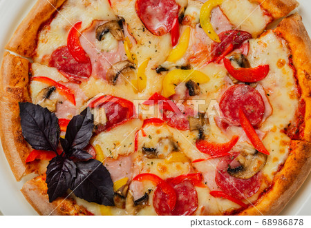 Fresh hot pizza on white plate in restaurant. Fresh hot pizza on white plate in restaurant. 68986878