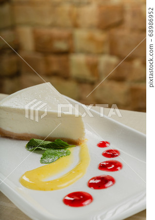 Fresh cheesecake on a white plate with jam in a 68986952