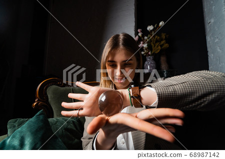Woman in business suit holding crystal ball 68987142