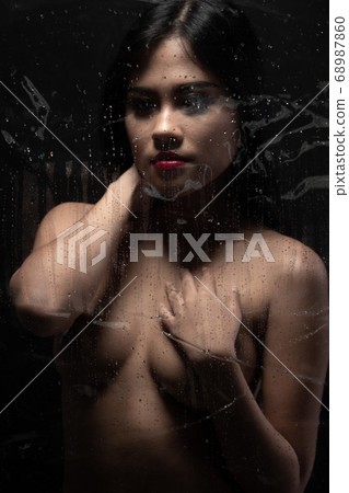 Perfect shape of woman body. Sexy art nude female. Naked sensual beautiful girl. Asian erotic light shadow and silhouette green leaf on breast over dark smoke background copy space Perfect shape of woman body. Sexy art nude female. Naked sensual beautiful girl. Asian erotic light shadow and silhouette green leaf on breast over dark smoke background copy space 68987860