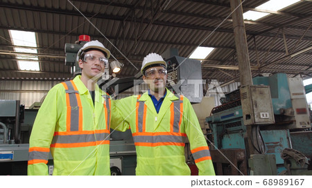 Group of factory workers using machine equipment in factory workshop 68989167