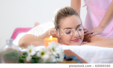 Woman gets back massage spa by massage therapist. 68989380