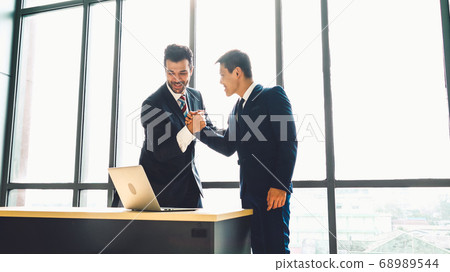 Two happy business people celebrate at office 68989544