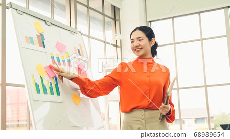 Young woman explains business data on white board 68989654