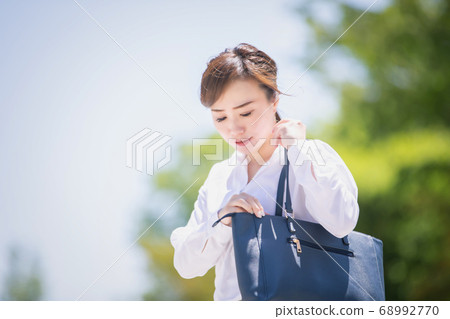 Business woman looking for something in bag 68992770