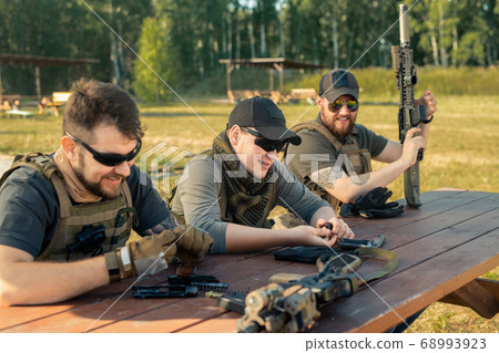 Men reloading guns Men reloading guns 68993923