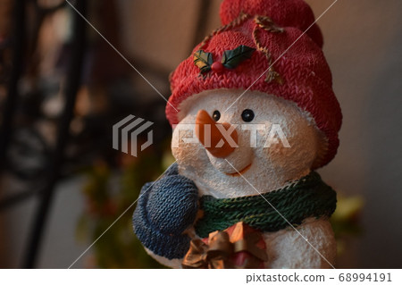A cute snowman figurine with a Christmas gift A cute snowman figurine with a Christmas gift 68994191