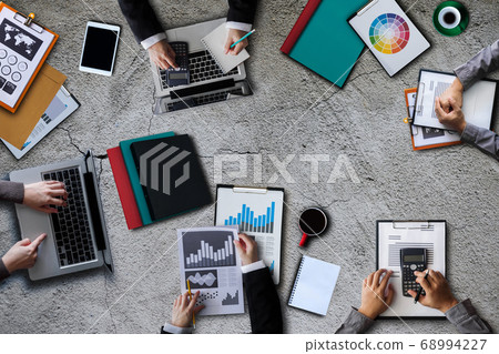 Top view of businessman Group of Multiethnic Busy People meeting with other in modern office with laptop computer, smartphone, tablet, coffee and document on table. Top view of businessman Group of Multiethnic Busy People meeting with other in modern office with laptop computer, smartphone, tablet, coffee and document on table. 68994227