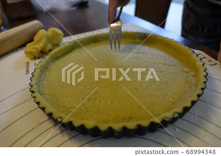 Punching the walnut pie dough with a fork 68994348