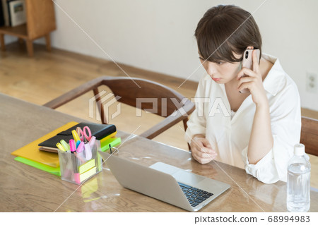 年輕女子在遠程辦公期間講手機 年輕女子在遠程辦公期間講手機 68994983