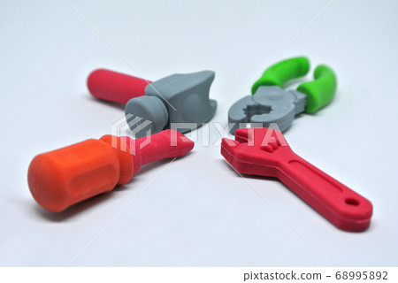 Toy carpentry tools are made of colorful soft rubber isolated on white background. Toy carpentry tools are made of colorful soft rubber isolated on white background. 68995892