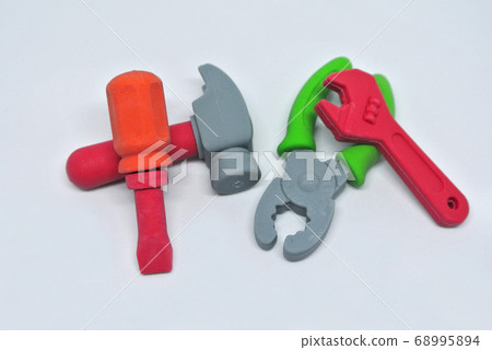 Toy carpentry tools are made of colorful soft rubber isolated on white background. Toy carpentry tools are made of colorful soft rubber isolated on white background. 68995894
