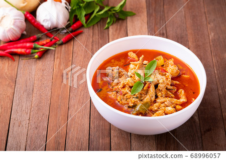 Thai curry red soup,Thailand tradition menu,boiled red curry with coconut milk and chicken on wood table Thai curry red soup,Thailand tradition menu,boiled red curry with coconut milk and chicken on wood table 68996057