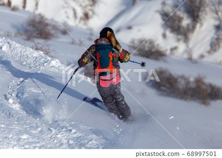 Man skiing in the snow in winter Man skiing in the snow in winter 68997501