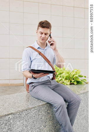 Serious businessman calling on phone Serious businessman calling on phone 68997558