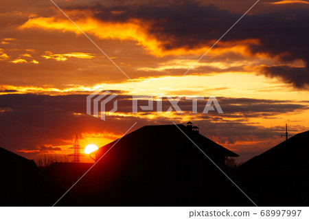 Sunset on the background of houses in the village Sunset on the background of houses in the village 68997997