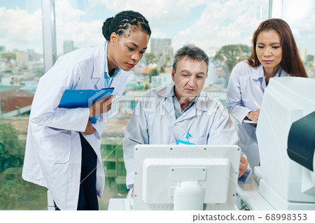 Ophthalmologists discussing medical test results 68998353