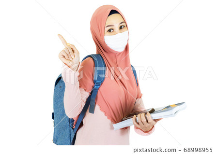beautiful young muslim asian woman with traditional dress wearing medical face mask  to go to school Under the outbreak of the virus isolated on white background,health care concept 68998955