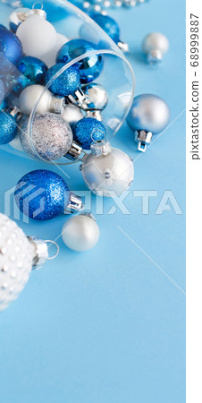 Christmas baubles in a wine glass on a light blue Christmas baubles in a wine glass on a light blue 68999887