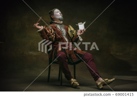 Young man as Johann Sebastian Bach on dark green background. Retro style, comparison of eras concept. Young man as Johann Sebastian Bach on dark green background. Retro style, comparison of eras concept. 69001415